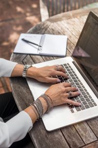 close-up of hands typing on a laptop