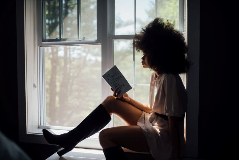 woman reading a book in window nook